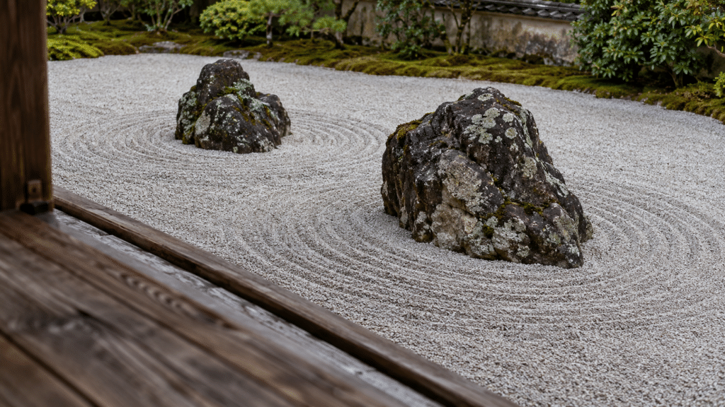 Hamparan kerikil tersisir rapi dan formasi batu berlumut di taman kering Zen karesansui kuil tradisional.